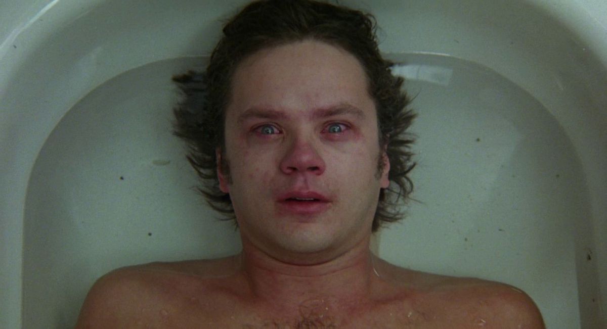 Tim Robbins as Jacob Singer, lying red-eyed in a bathtub full of water.
