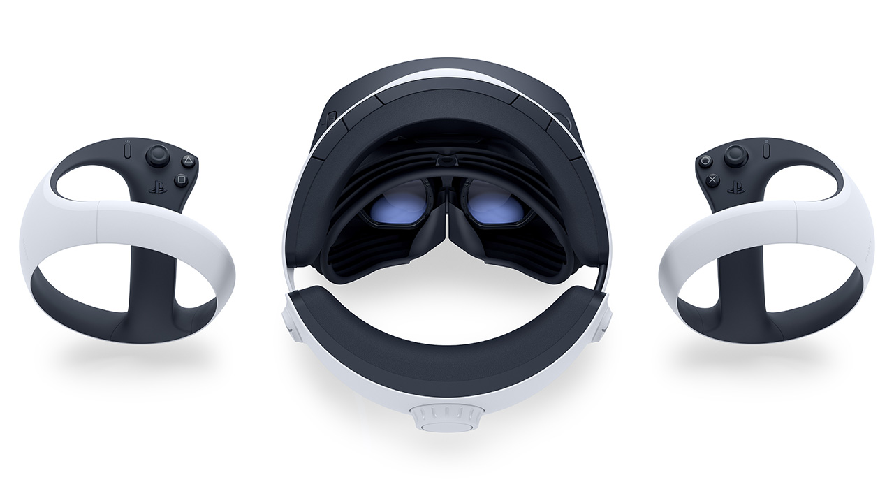 PSVR 2-headsetet, sett från ovan, vilar på en vit yta, flankerad av båda VR2 Sense-kontrollerna
