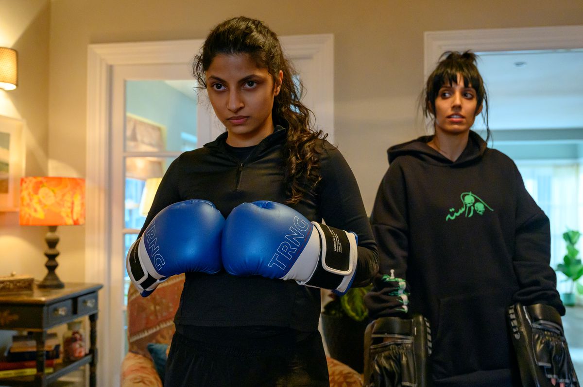 Ria, en brittisk-pakistansk tonåring, bär en svart skjorta och boxningshandskar som hon trycker mot varandra och ser bestämd ut.  Bakom henne finns hennes syster Lena, som bär en svart luvtröja och håller två slagkuddar för Ria att slå.  De är dock nere för tillfället när hon ser på Ria.