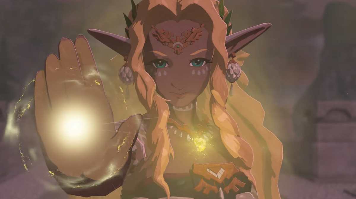 En bild av en tomteliknande karaktär från The Legend of Zelda: Tears of the Kingdom.  De har långt hår och långa spetsiga öron.  Deras hand lyser gult och det är deras halsband också när de såg bestämda ut i kameran.