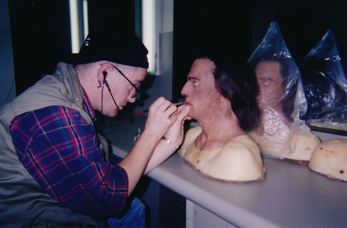 Ett foto visar Mitchell Coughlin måla munnen på en mask som står på ett skrivbord.