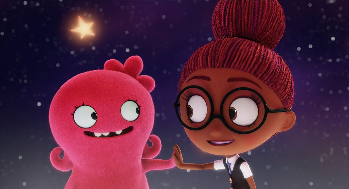 A pink ugly doll holding a hand out to a young girl 