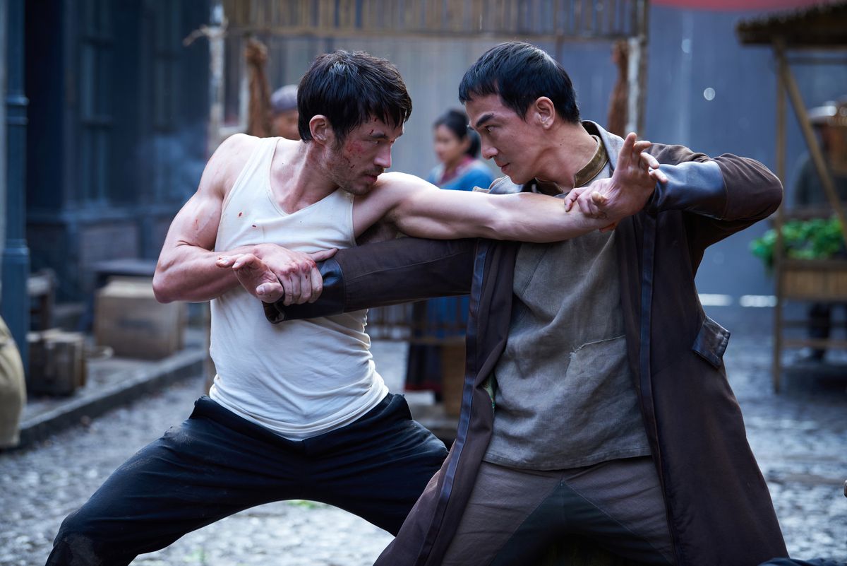 Andrew Koji and Joe Taslim are locked in a martial arts duel, each gripping the other man’s wrist and locking eyes, in Warrior season 3.