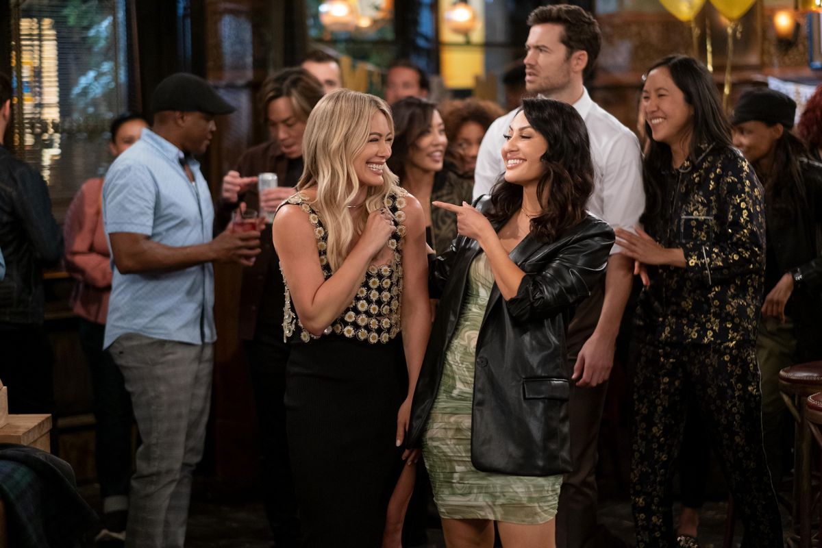 Sophie (Hilary Duff), Valentina (Francia Raisa), Charlie (Tom Ainsley), and Ellen (Tien Tran) smile together at a bar in How I Met Your Father.