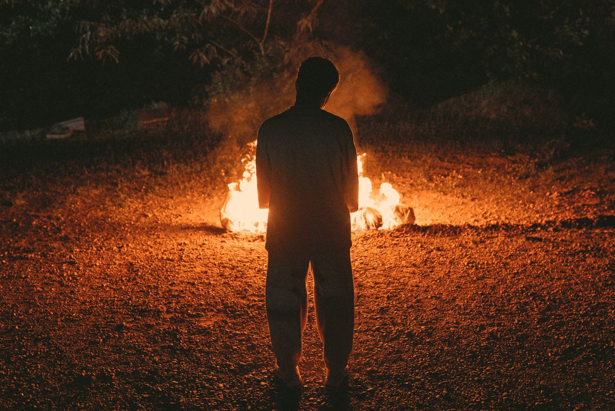 A figure stands in front of a bonfire in the middle of the woods at night in the trailer for Prime Video’s Swarm.