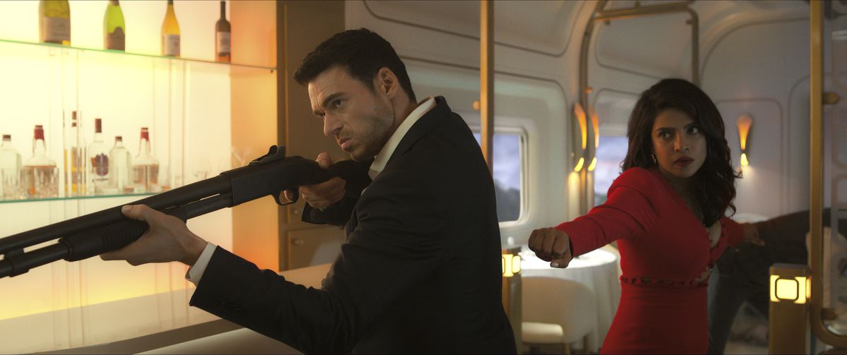 Mason Kane (Richard Madden) sights down a shotgun in a fancy train car, a Nadia Sinh (Priyanka Chopra Jonas) winds up for a swing in Citadel. 