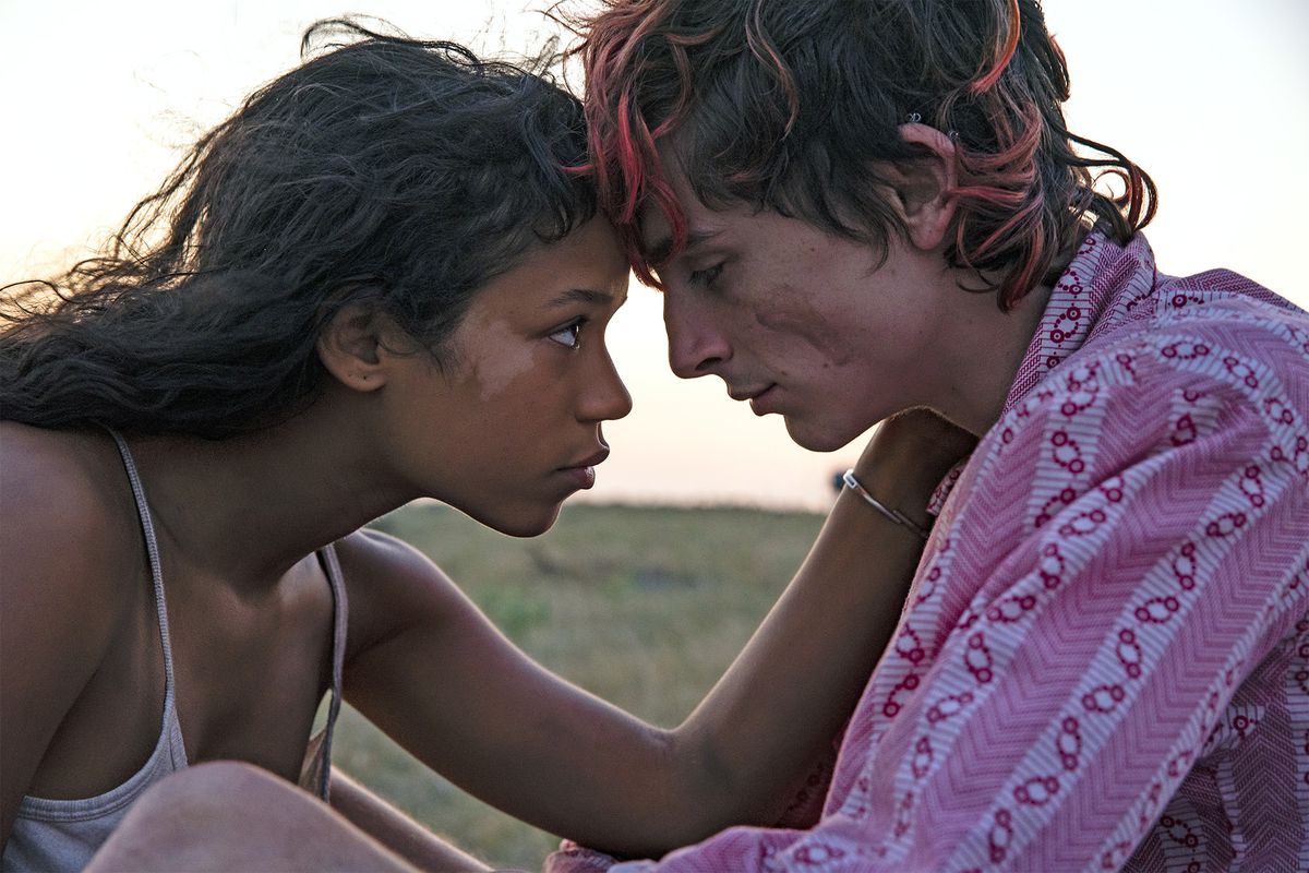 En ung kvinna (Taylor Russell) placerar sin panna mot en ung man (Timothee Chalamet) med stråk av rosa färg i håret.