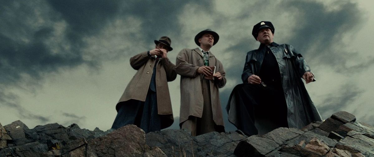 Three detectives stare out over a cliffside in Shutter island