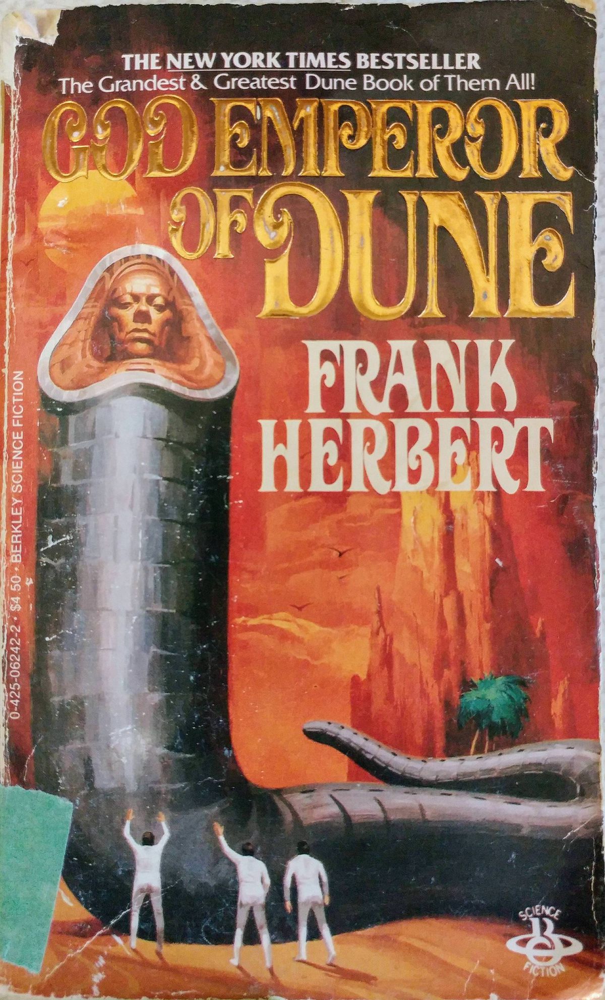 Berkley Books-omslaget från 1984 till God Emperor of Dune, med tre män i vitt stående vid basen av en höga grå, skalad maskformad figur med ett mänskligt ansikte där munnen skulle vara