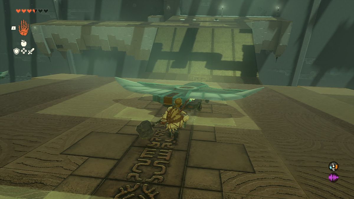Link springer efter en vagn med en vinge på som rullar nerför en kulle i Zelda Tears of the Kingdom.