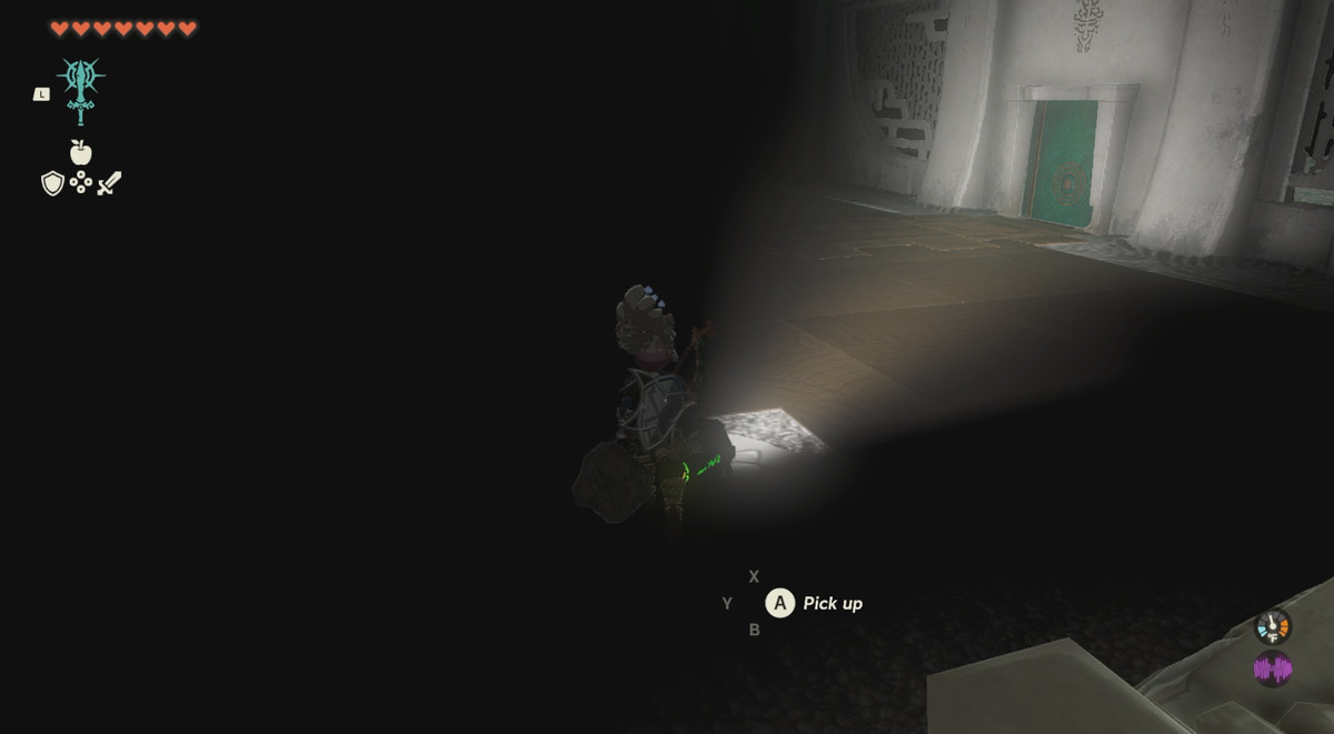 En mörk plats där Link riktar en ficklampa mot en grön dörr i Zelda: Tears of the Kingdom