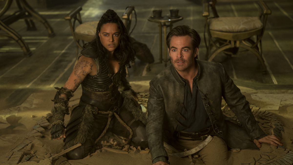 Michelle Rodriguez and Chris Pine look surprised while kneeling on the floor in Dungeons & Dragons: Honor Among Thieves.