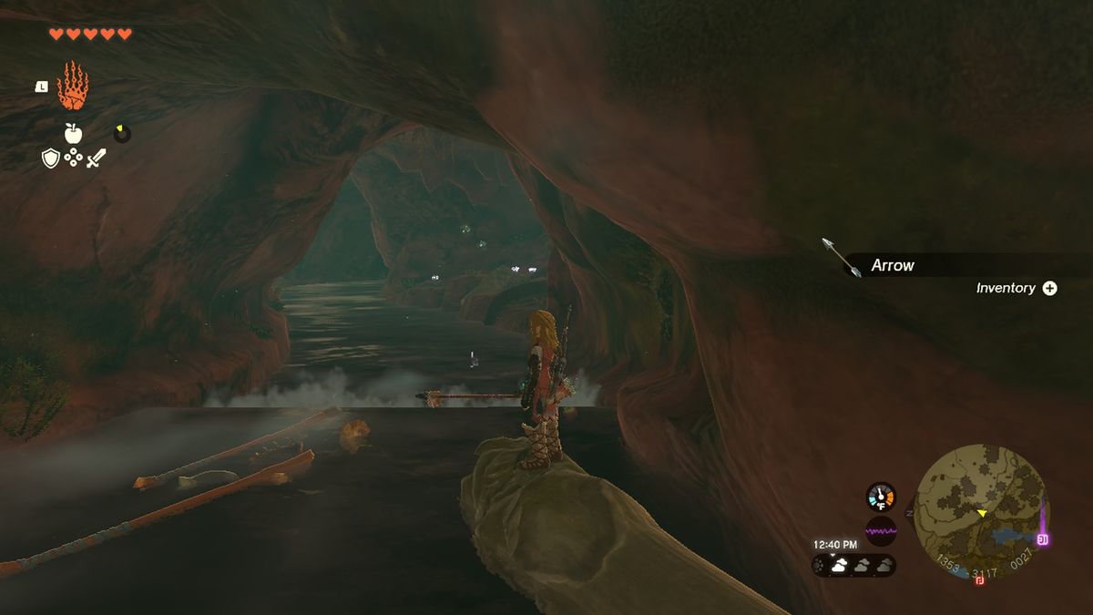 Link rider en stock nerför en flod i en grotta med gummirustningen i Zelda Tears of the Kingdom.