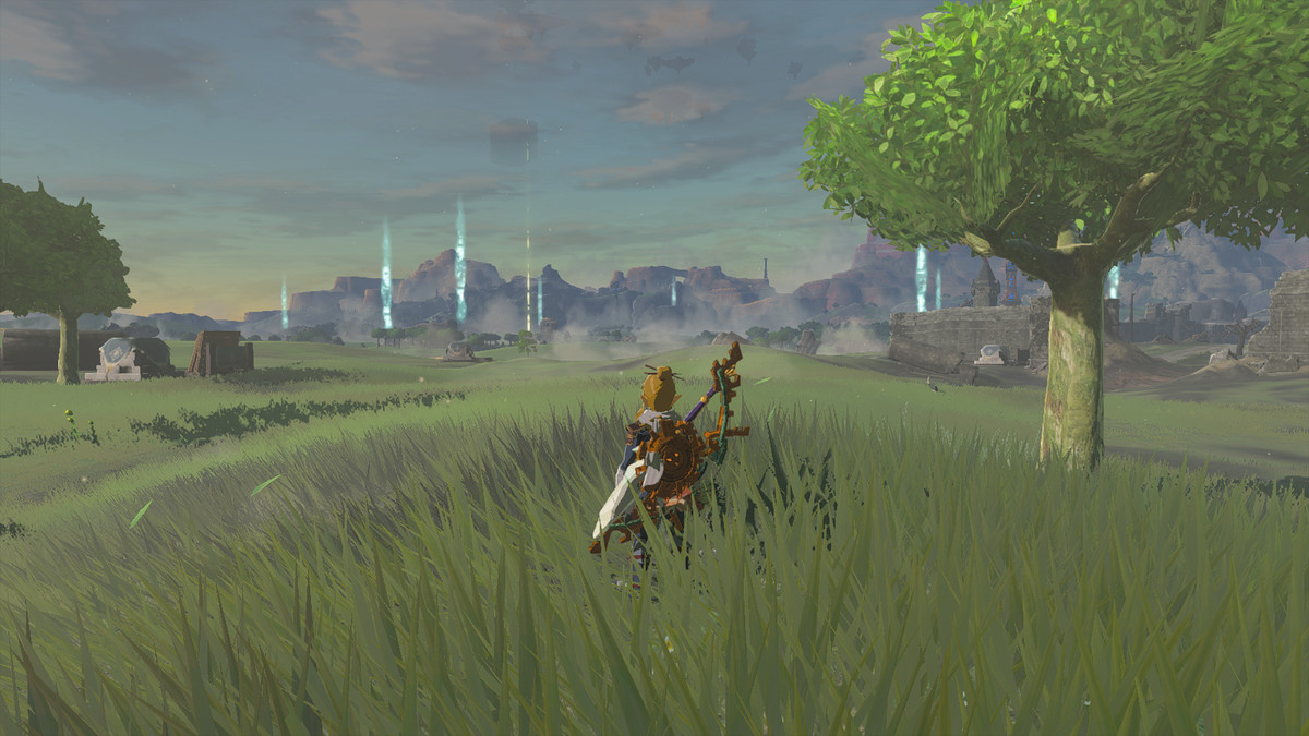 En bild av Link som står på ett fält i The Legend of Zelda: Tears of the Kingdom.  Avlägsna ljuspelare markerar ingångarna till grottorna. 