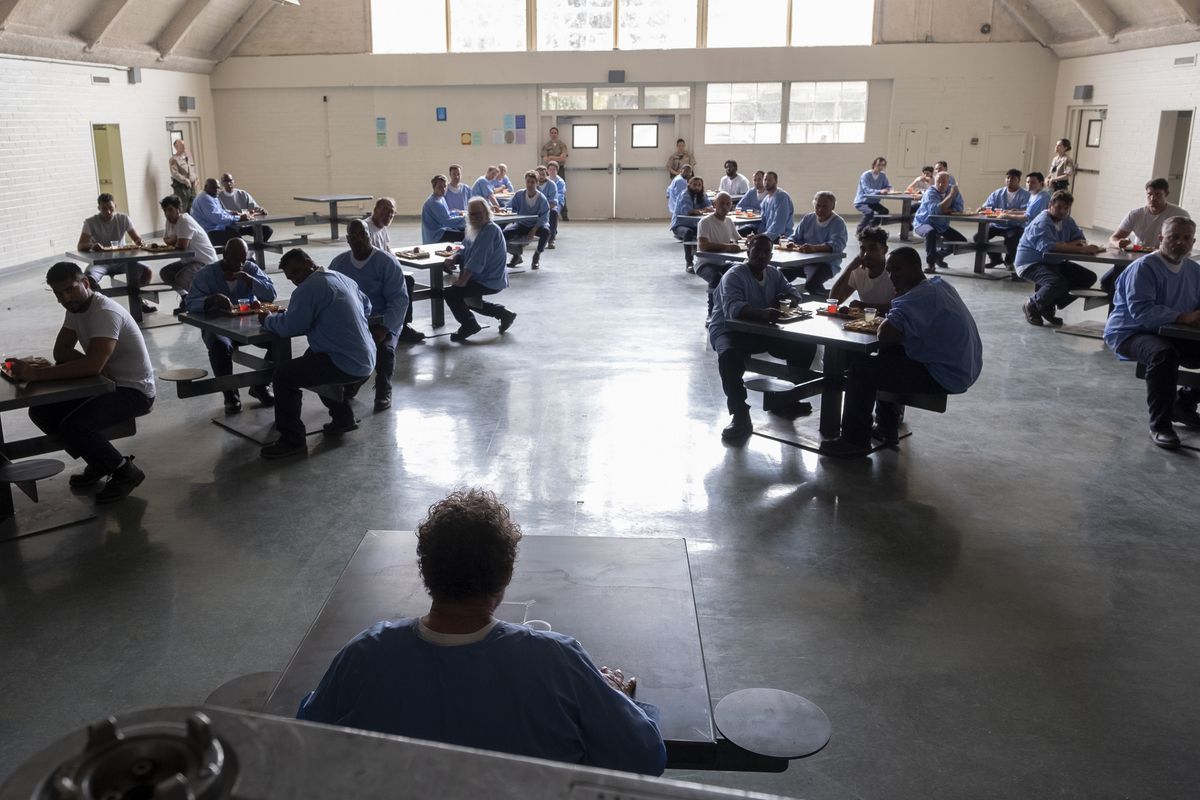 Fuches (Stephen Root) står med sin bricka framför fängelsekafeterian, där alla tittar på honom.