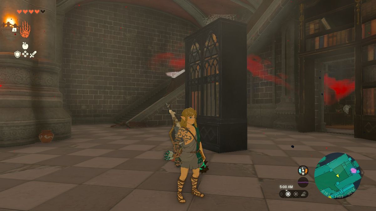 Link står bredvid en bokhylla nära trappor i Hyrule Castle i Zelda Tears of the Kingdom.
