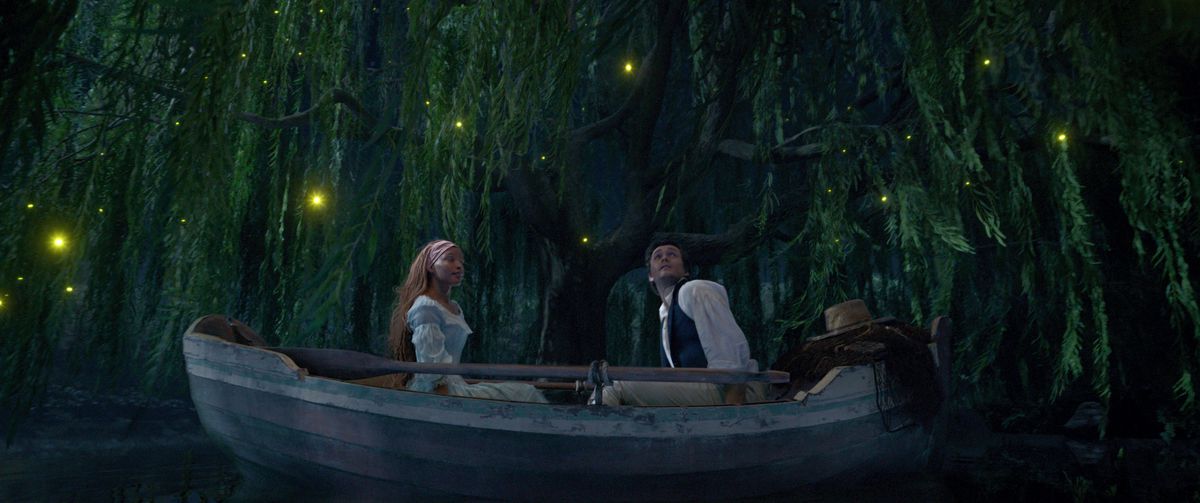 Ariel och Eric sitter på motsatta ändar av en kanot i en blå lagun.