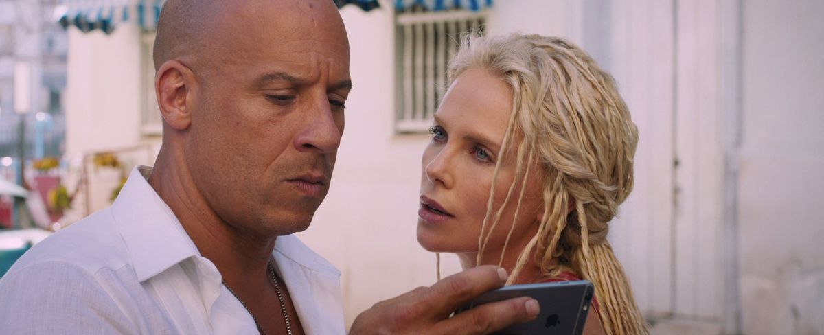 Dom Toretto (Vin Diesel) tittar på en telefon medan Cipher (Charlize Theron) tittar på i F8: The Fate of the Furious