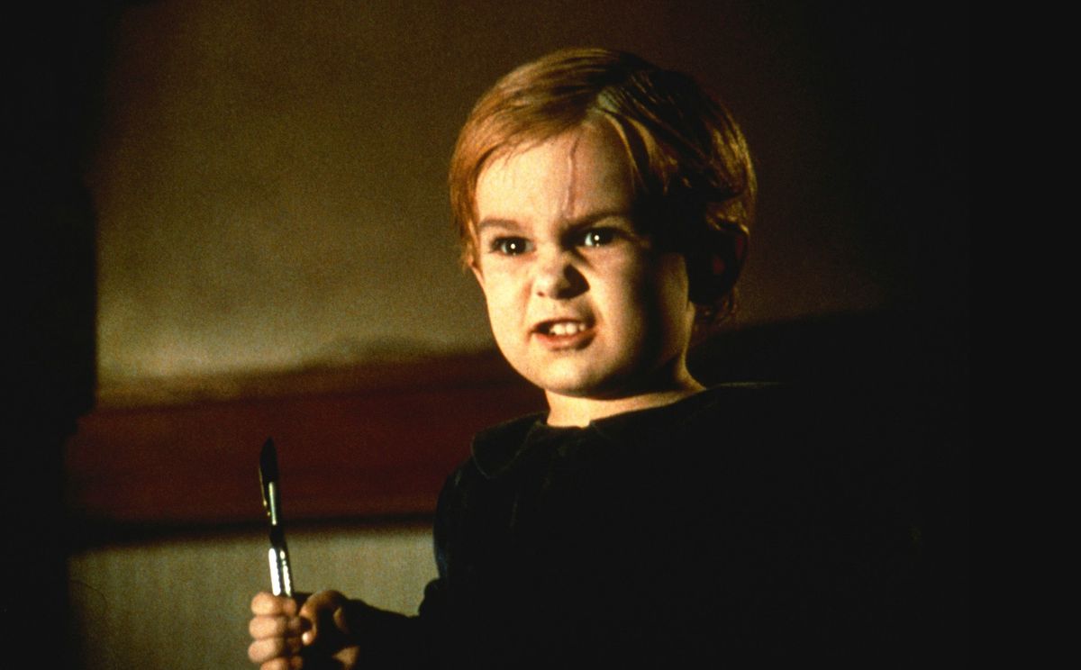 A toddler with a sneer on his face, a livid scar running down his forehead, and a scalpel in his head from the 1989 movie Pet Sematary