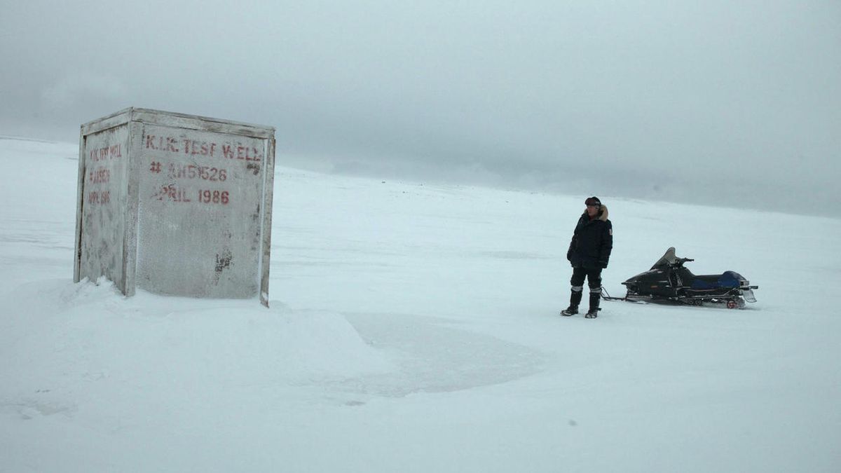 En man som står framför en vit container mitt på den antarktiska tundran i The Last Winter.