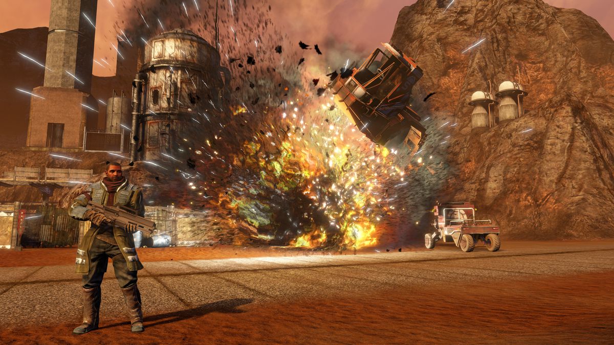 Red Faction: Guerrilla Re-Mars-tered Edition - Alec Mason standing as vehicles explode behind him.