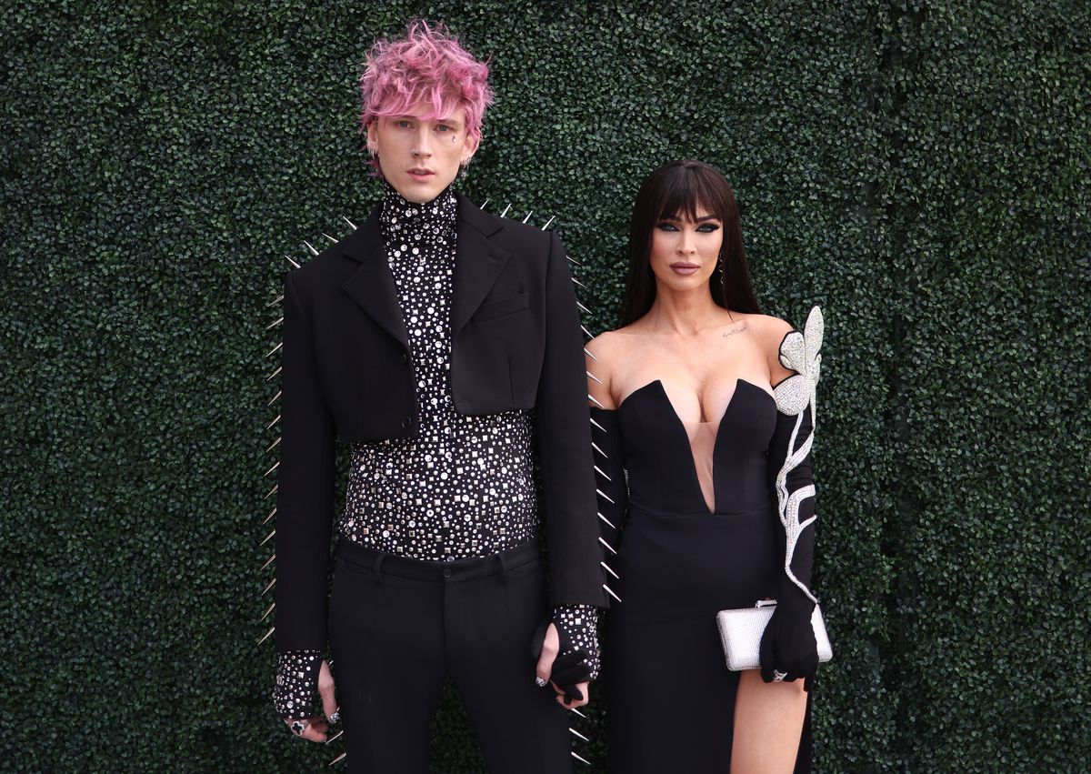 Machine Gun Kelly med rosa hår och taggiga svarta kläder och Megan Fox med en svart lugg och en svartvit moddklänning på 2022 års Billboard Music Awards röda mattan