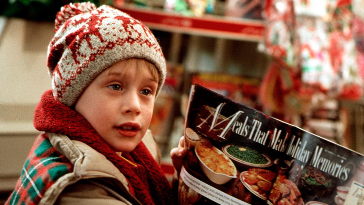 Macaulay Culkin holds open a magazine advertising a delicious Christmas dinner in Home Alone.