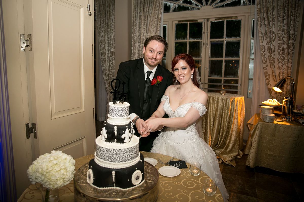 Två personer skär en tårta med vampyrtema på sitt bröllop