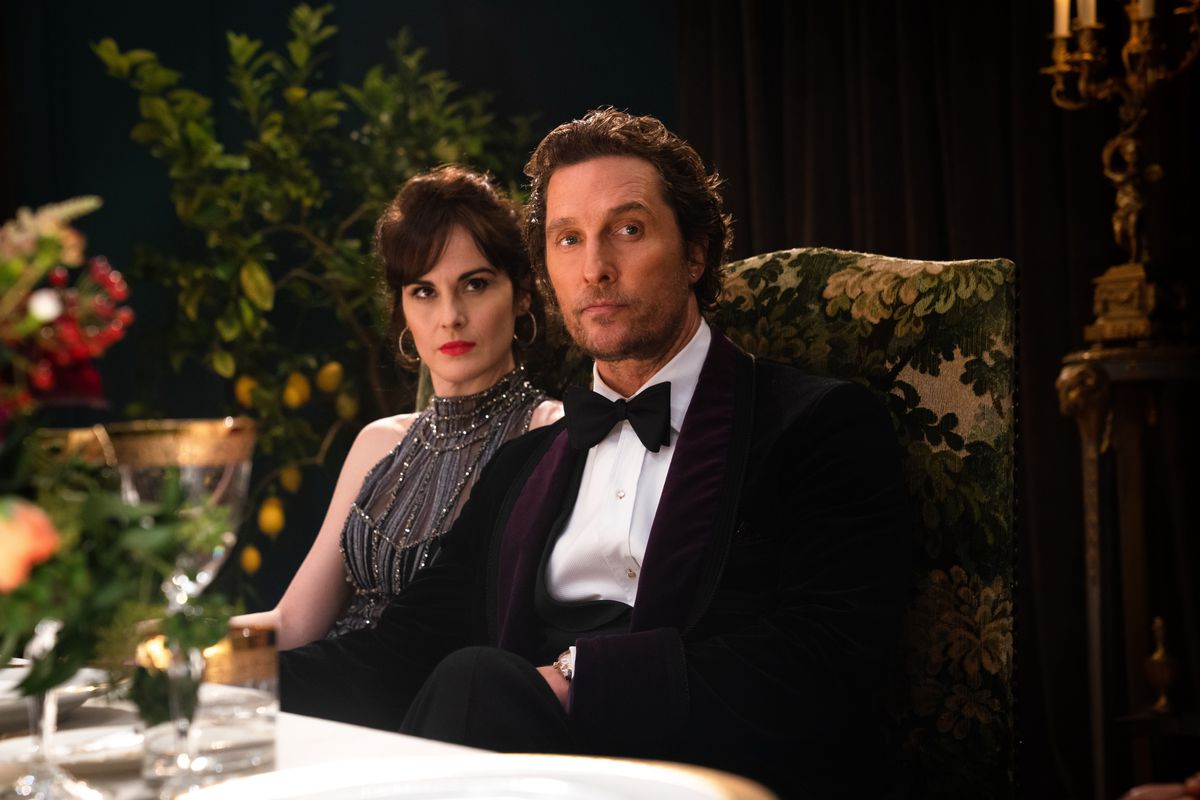 en kvinna (Michelle Dockery) och en man (Matthew McConaughey) i snygg klänning sitter vid ett matbord i The Gentlemen