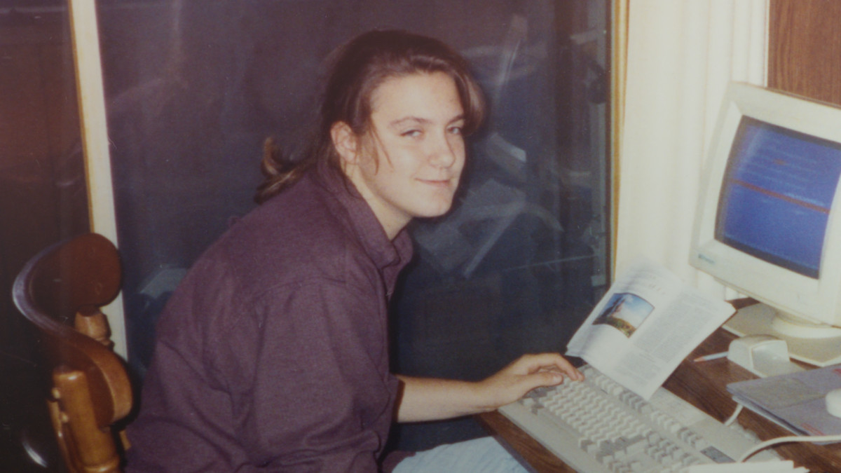 En kvinna kramar över en gammal dator