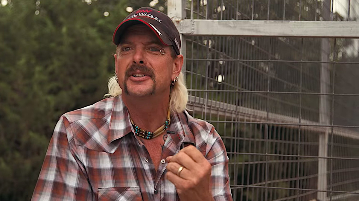 Joe Exotic sitter vid en stor tigerbur och talar in i kameran i en skärmdump från Tiger King.