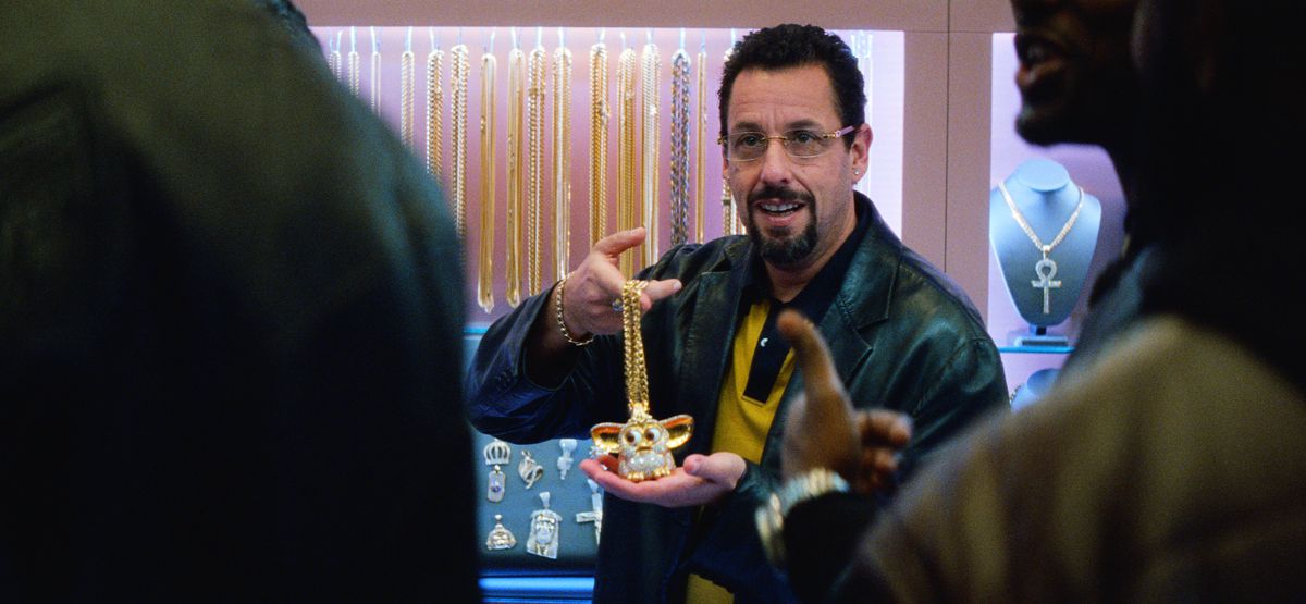 Howard Ratner (Adam Sandler) håller upp ett diamantkrypat Furby-halsband