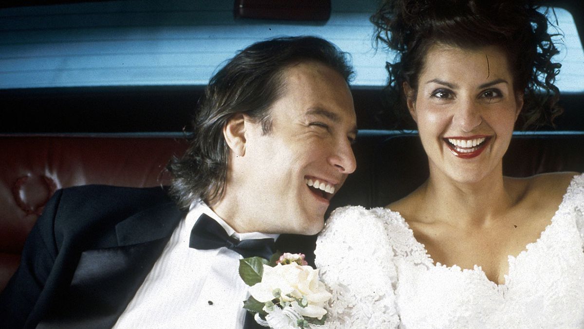 Ian (John Corbett) och Toula (Nia Vardalos) skrattar i baksätet i en bil i en skärmdump från My Big Fat Greek Wedding