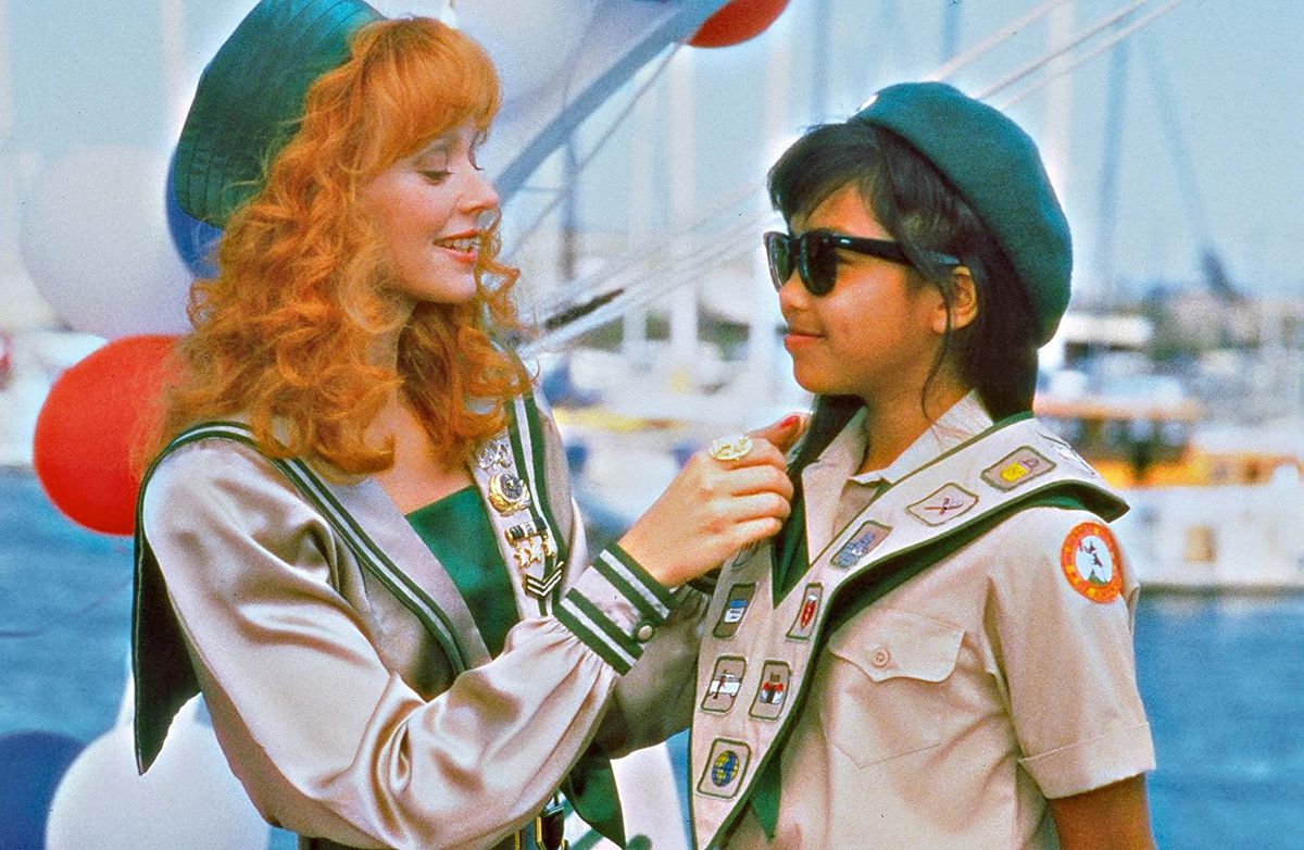Shelly Long hjälper en scout med hennes märke i en skärmdump från Troop Beverly Hills