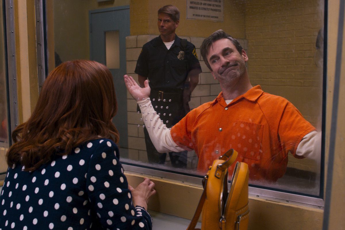Jon Hamm som pastor i obrottslig Kimmy Schmidt bär en orange fängelseshoppar och rycker avskräckligt mot Kimmy från andra sidan av fängelset.