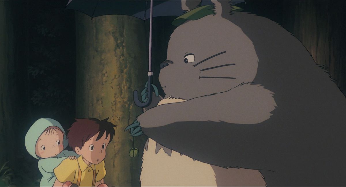 Totoro räcker Satsuki och Mei med ett bunt ekollon