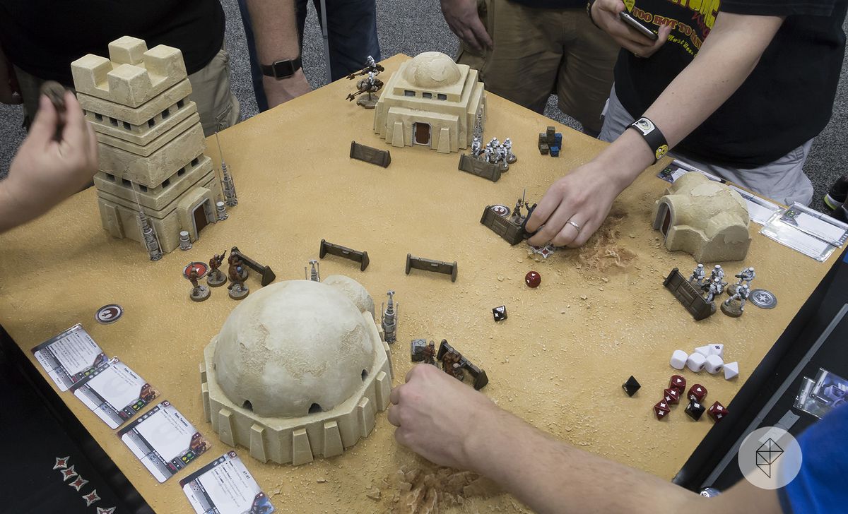 Gen Con 2017 - händer sträcker sig in i ett diorama av Tatooine från Star Wars: Legion