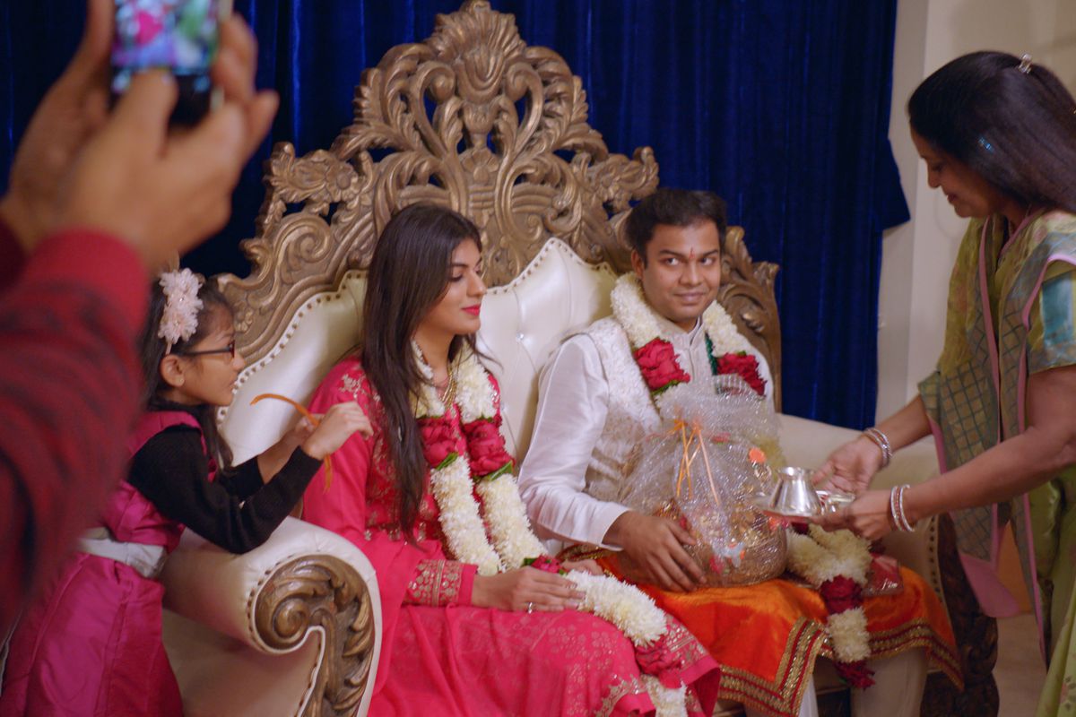 Ett par sitter tillsammans på en genomgripande kärlek i guld- tronstil i Netflix Indian Matchmaking.