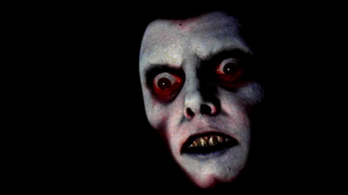 Ett skrämmande ansikte skymtar fram ur mörkret i Exorcisten.
