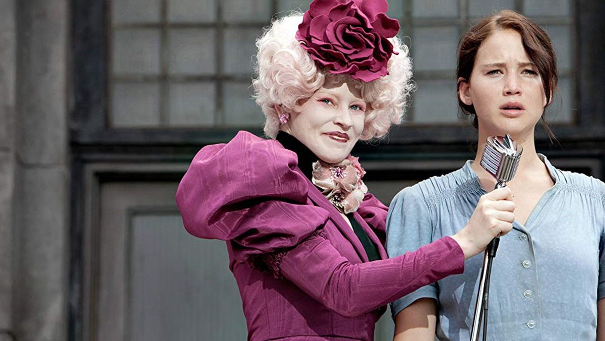 Effie (Elizabeth Banks) håller en mikrofon ut till Katniss (Jennifer Lawrence)