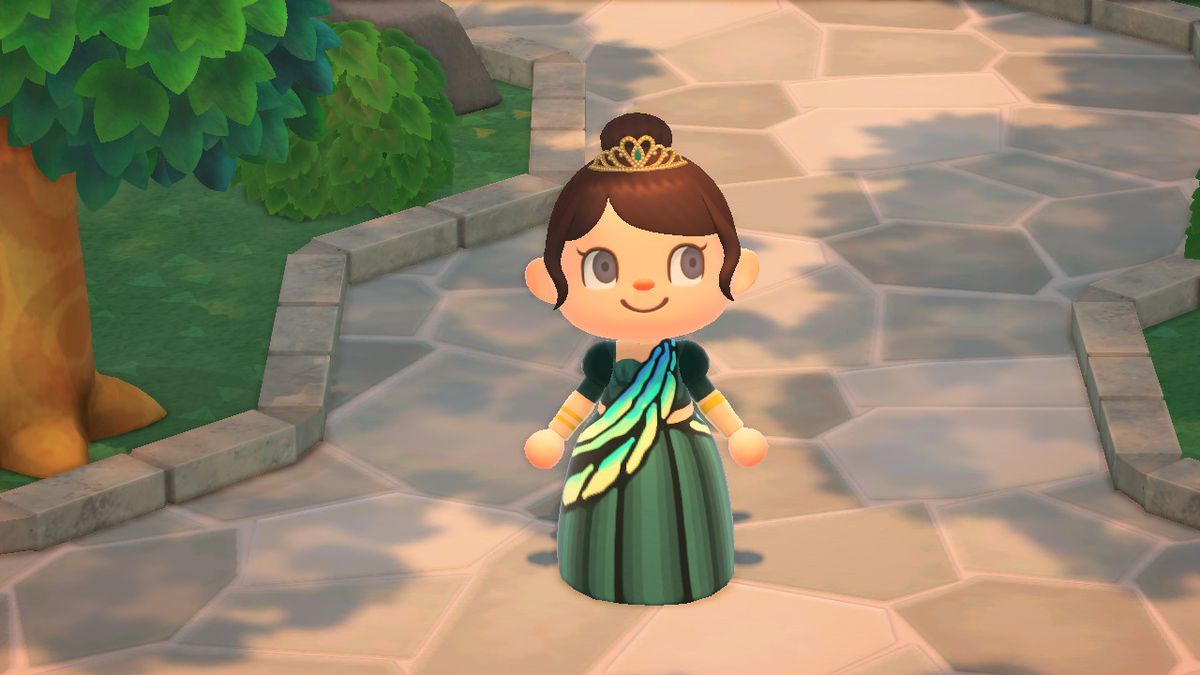 Animal Crossing: New Horizons - en karaktär, klädd i en tiara och en skräddarsydd fjärilsklänning, står mitt i en stenväg under ett träd.