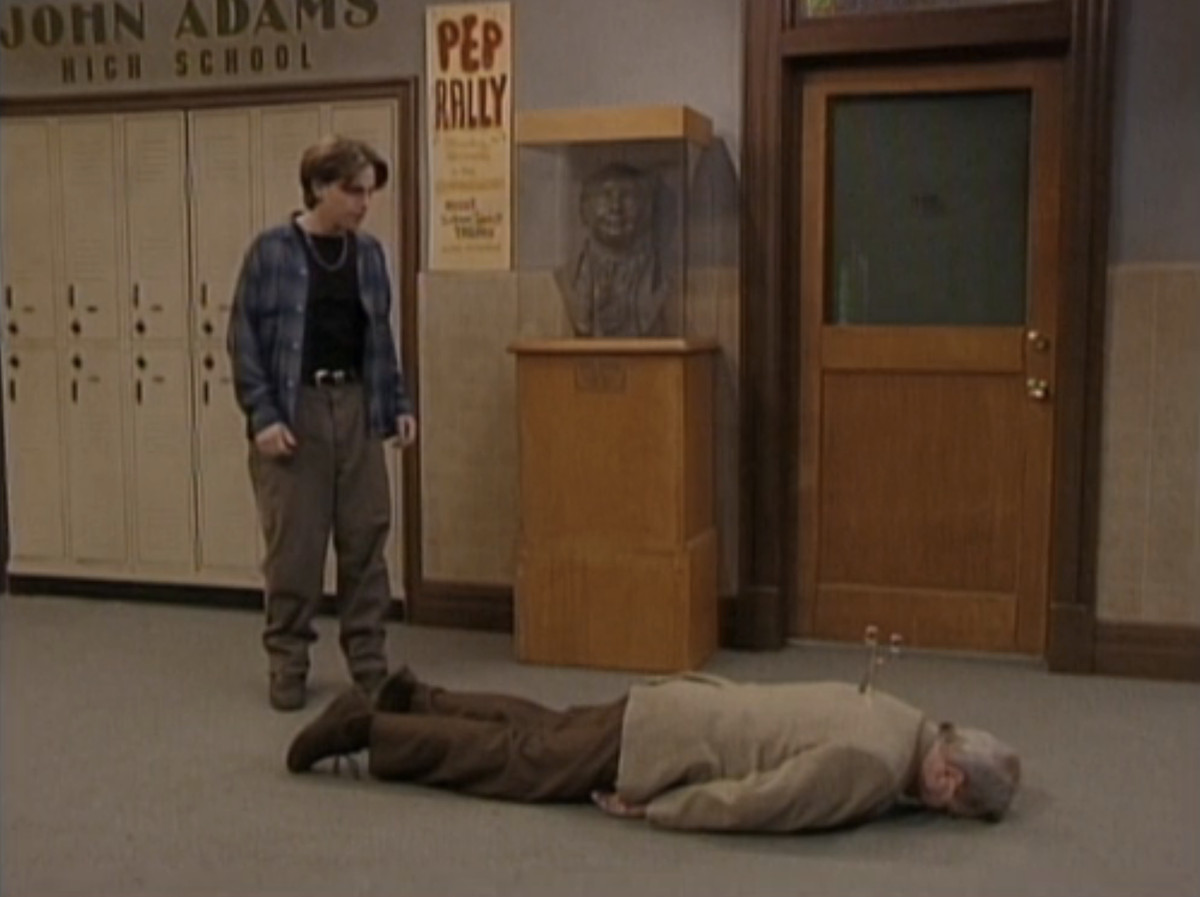 Shawn tittar ner på en död herr Feeny med en sax som sticker ut ur ryggen