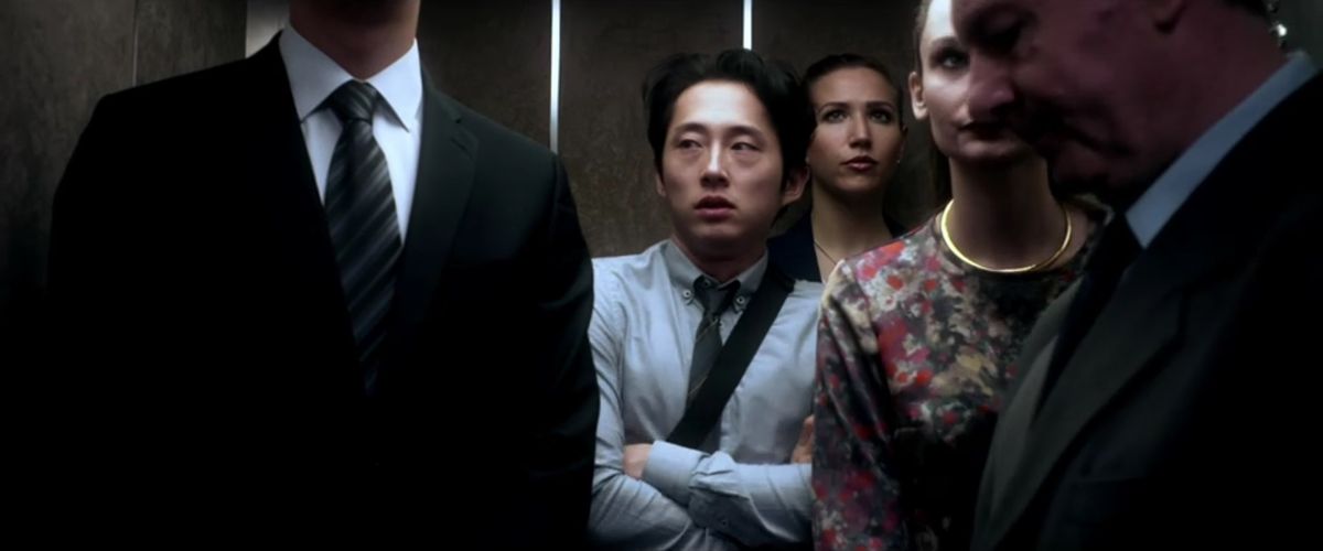 En stillbild från Mayhem som visar Steven Yeun i en full hiss