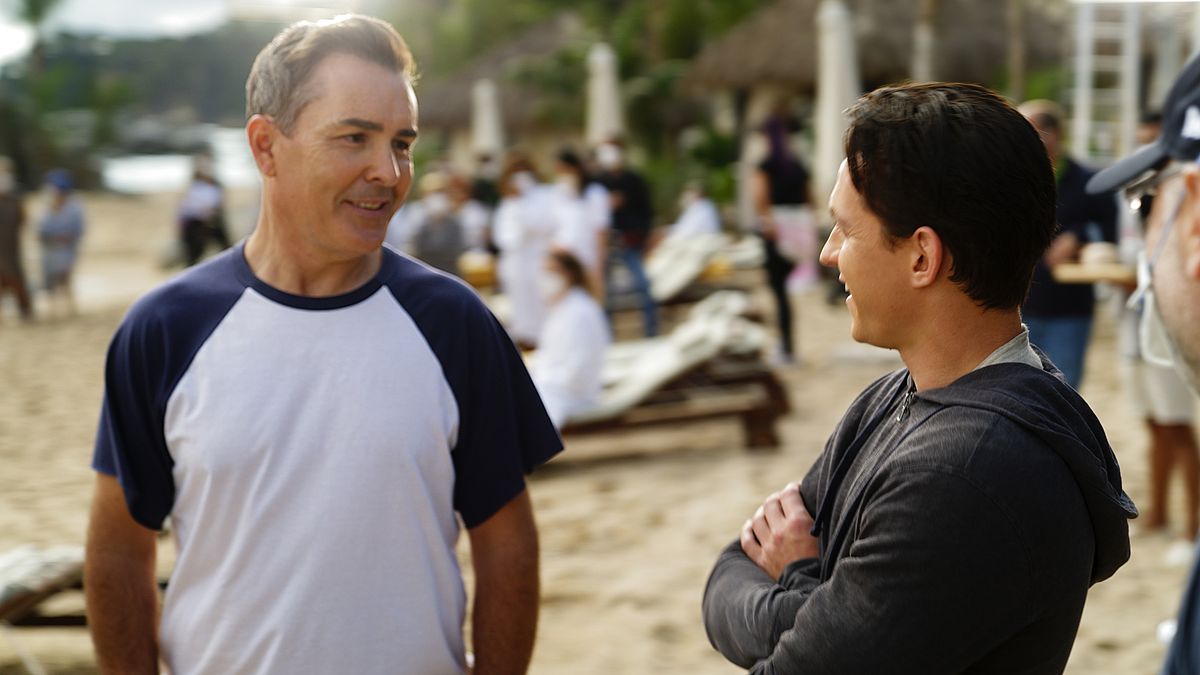ett foto av Nolan North tittar på Tom Holland på stranden, på uppsättningen av Uncharted-filmen