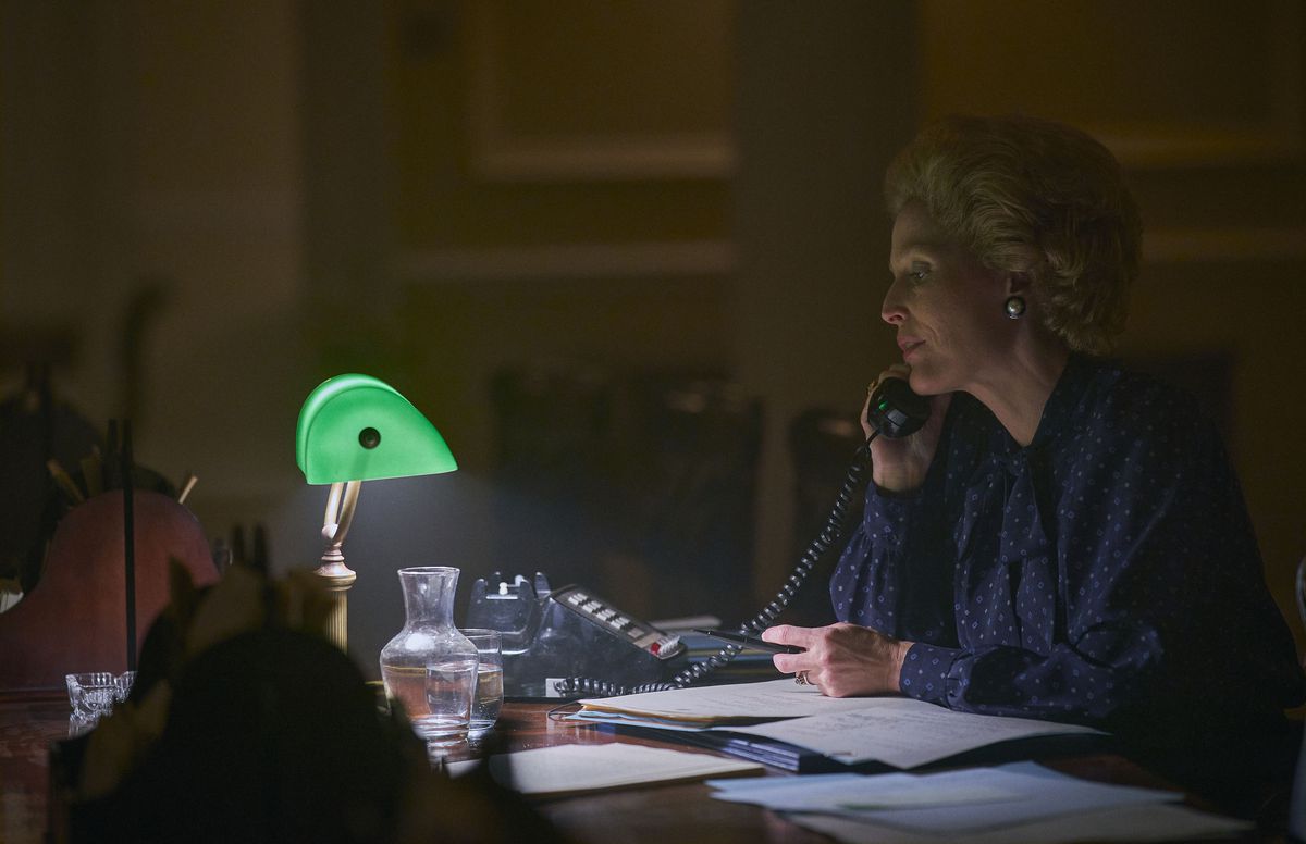 Gillian Anderson som Margaret Thatcher, sitter vid ett svagt upplyst skrivbord på telefonen i The Crown