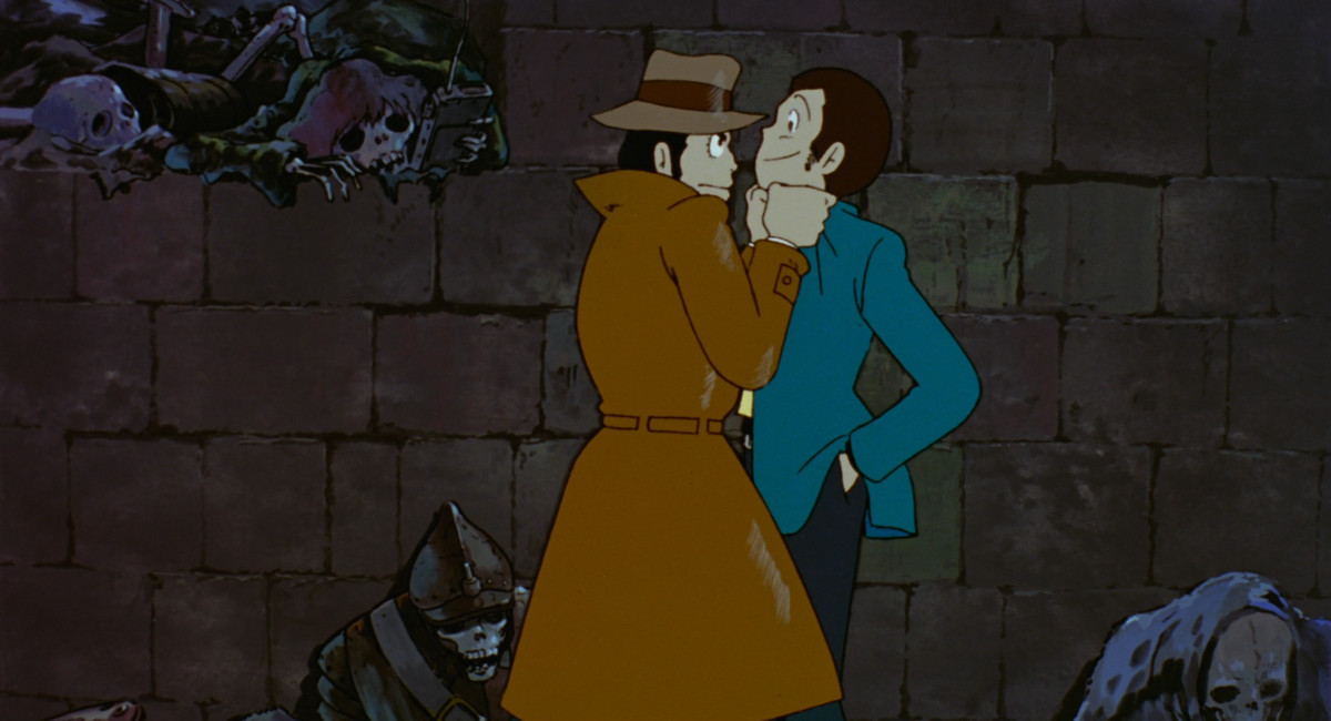 Interpolinspektör Zenigata håller mästertjuven Lupin III vid kapporna i en skelettfylld krypt i slottet Cagliostro