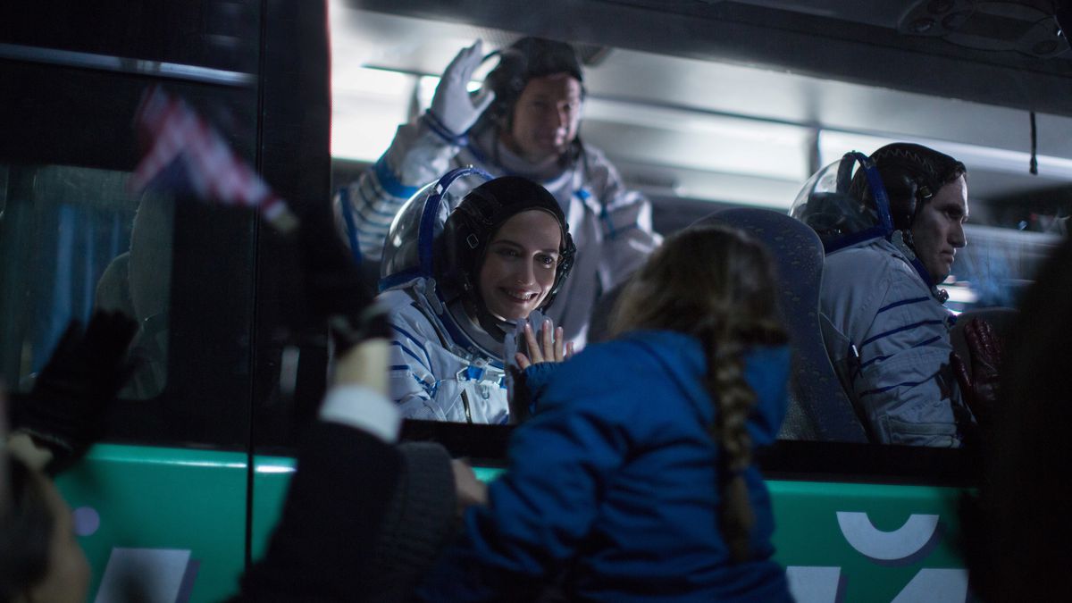 Eva Green, i full astronaututrustning, når ut till sin dotter genom en glasruta i Proxima