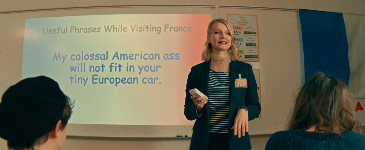 en fransk lärare framför en powerpoint-bild som säger Min kolossala amerikanska röv passar inte in i din lilla europeiska bil
