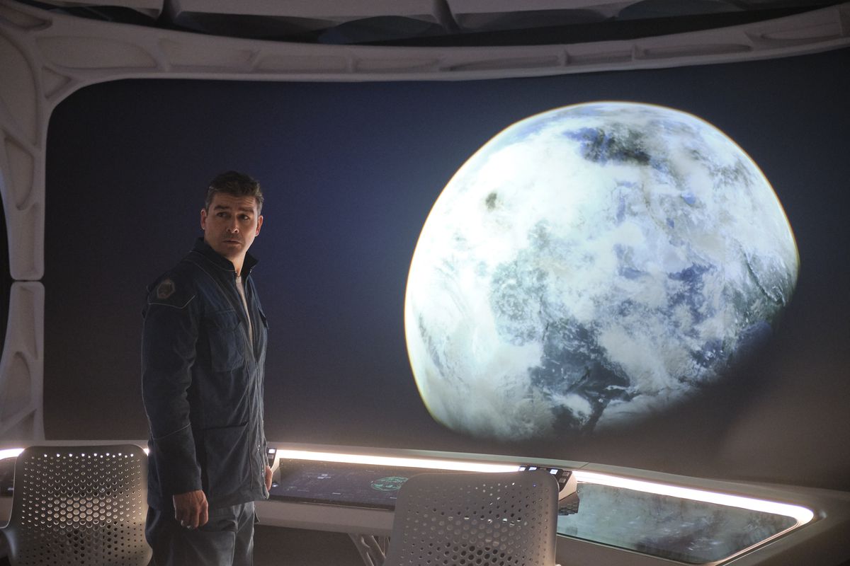 Kyle Chandler tittar ut genom ett fönster på en planet i Midnight Sky
