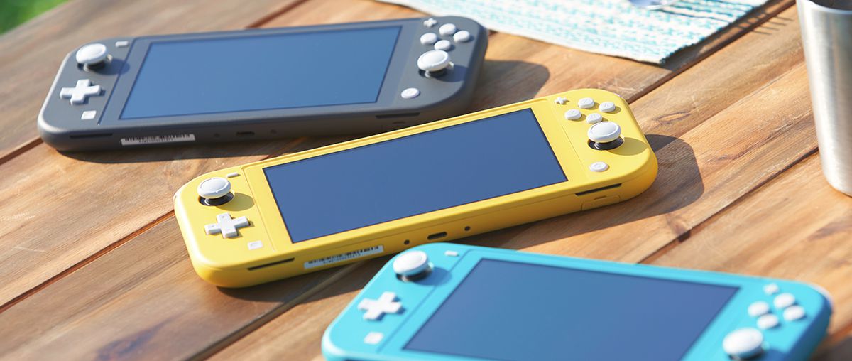 Three Nintendo Switch Lites laying on a table. One is yellow, one is grey, and the other is turquoise.